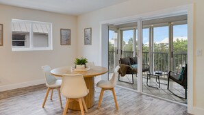 Un coin repas avec une table ronde, des chaises et une plante.