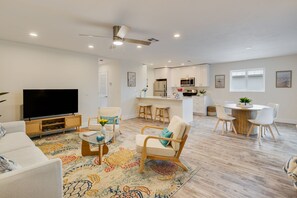 A modern living room with a flat-screen TV, a sofa, a coffee table, and a patterned rug. - Sanibel Arms A8- Gorgeous Condo Steps to Beach (Sanibel)