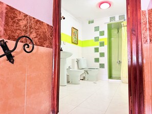 Une salle de bain avec des toilettes, un lavabo et un miroir.