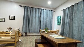 Un comedor con una mesa de madera, bancos y un ventilador de techo.
