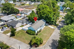 An aerial view of a residential area with houses, a prominent red location marker, and a large tree. - "Coastal Belle" By Beach Star Near Marsh Walk (Murrells Inlet)