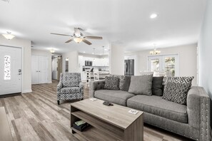 Ein modernes Wohnzimmer mit einer Couch, einem gemusterten Sessel und einem Couchtisch.