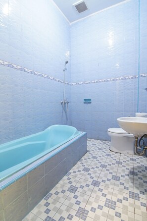 Un baño con bañera, inodoro y lavamanos.