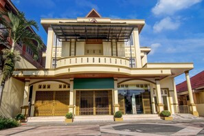 A two-story building with a balcony, a gated entrance, and a covered walkway.