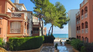 A coastal hotel with balconies, a paved walkway, and a view of the sea. - Impressive penthouse on the seafront (PEÑISCOLA)