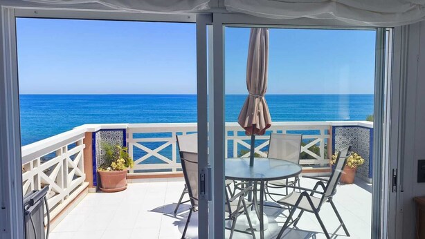 A balcony with a table and chairs, a potted plant, and a view of the sea. - Impressive penthouse on the seafront (PEÑISCOLA)