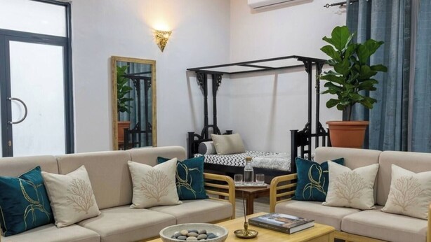 A living room with a sofa, coffee table, and a ceiling fan.