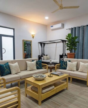 A living room with a sofa, coffee table, and a ceiling fan. - Azure Chameleon House. (Jambiani)