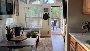 A kitchen with wooden cabinets, a stove, and a dining area with a rug.