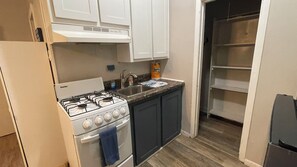 A kitchen with a gas stove, a sink, and cabinets. - Charming Efficiency Unit w/Cool AC in Aransas Pass (Aransas Pass)