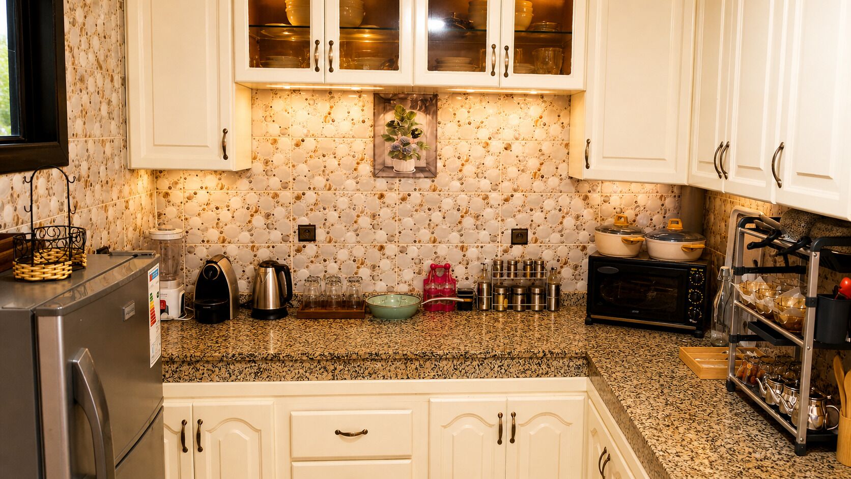 A kitchen with white cabinets, a granite countertop, and a backsplash with a speckled pattern.