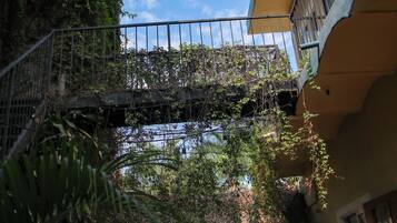 Ein Gebäude mit Balkon, Brücke und einem geparkten Auto davor.