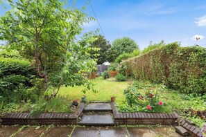 Ein Garten mit einem Ziegelweg, der zu einem Haus führt.
