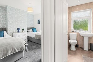 A bedroom with a bed, bedside table, and a nightstand. - Spacious Home with Garden for Groups & Families (Greater Manchester)