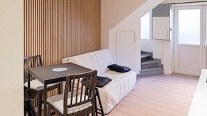 A modern living space with a dining area, a sofa, and a staircase. - Quiet duplex ground floor - Center Puy - GR65 stage (Le Puy)