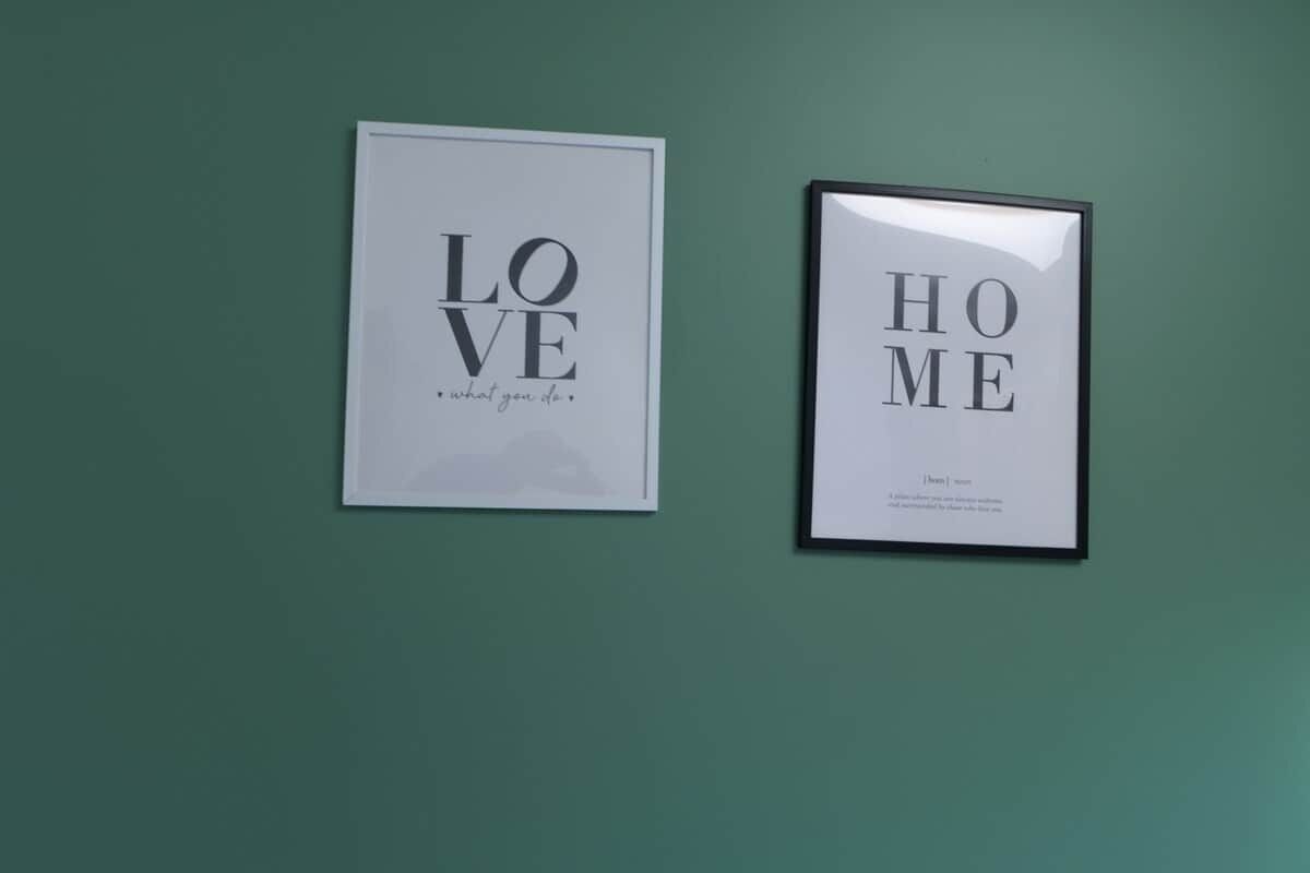 Two framed signs on a wall, one reads 'LOVE what you do' and the other 'HOME'.