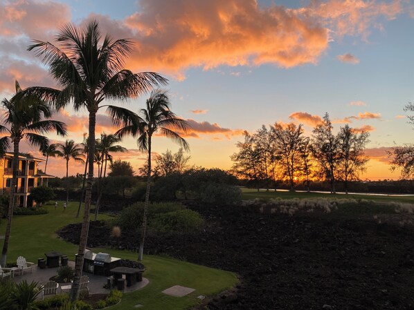 A resort with a pool, outdoor seating, and a view of the sunset. - Quiet Luxury at Kings’ Land – 2BR Villa with Golf & Resort Amenities (Waimea)
