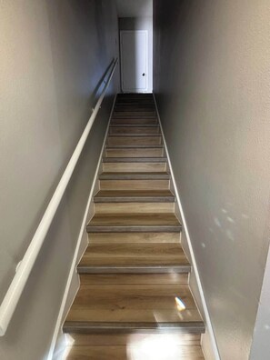 A staircase with wooden steps and white handrails, leading to a door at the top. - Nice 2 Bedroom/3 Beds/1.5 Bath Apartment - Bryant3 (Bryant)