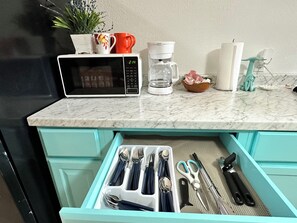 A kitchen with a microwave, coffee maker, and utensils drawer. - Hidden Oasis- 2 bdrm 2 bath home (Port O'Connor)
