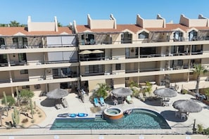 Un hôtel doté d’une piscine, de plusieurs balcons et d’espaces extérieurs aménagés pour se détendre.