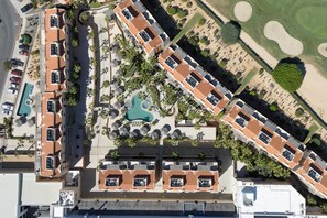 An aerial view of a resort with multiple buildings, a swimming pool, and landscaped areas. - Charming Golf-view Condo With Pool, Hot Tub, Terrace & Wifi (San José del Cabo)