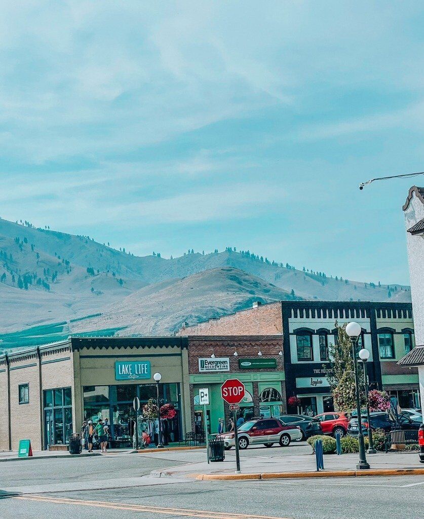 Katunäkymä, jossa näkyy liikennemerkki, rakennus, jonka kyltissä lukee ”Lake Life”, ja taustalla vuori.