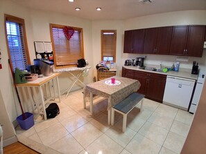 Una cocina compacta con una mesa de comedor, un banco y armarios de madera.