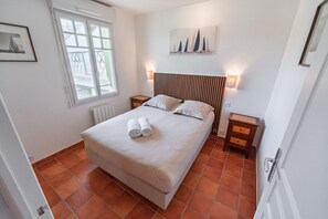 A bedroom with a bed, two bedside tables, a window, and a wall-mounted artwork. - La Parenthèse dorée - À moins d’1 km de la plage (Plurien)