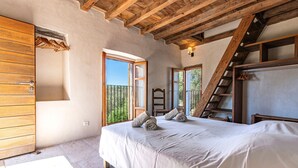Quarto com cama, guarda-roupa de madeira e escada.
