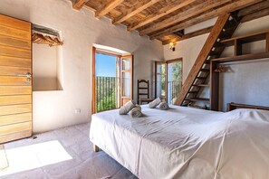Ein Schlafzimmer mit einem Bett, einem Holzschrank und einer Treppe.