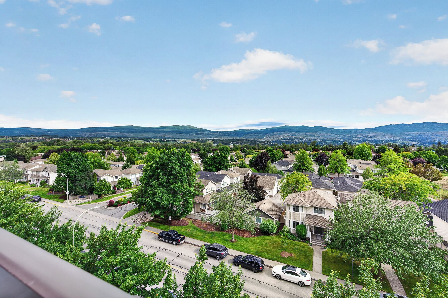 Un quartier résidentiel avec des maisons, des rues et une chaîne de montagnes visible au loin.