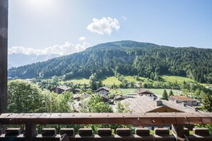 A mountain village with houses, a sports field, and a clear sky. - Cocon des Aravis - Beau duplex avec balcon (Le Grand Bornand)