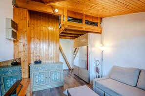 Ein Holzinnenraum mit einer Couch, einem Schrank und einer Treppe.