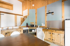 Eine kleine Küche mit Holzausstattung, einer Mikrowelle, einem Toaster und einem Spülbecken.