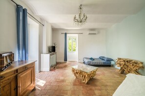 Une pièce comprenant un meuble en bois, une table basse en verre, un canapé et une table d’appoint en bois.