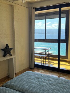 A bedroom with a large window, a star decoration, and a view of the sea. - Vrbo Property (Ajaccio)