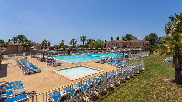 Ein Poolbereich mit mehreren Pools, Liegestühlen und Sonnenschirmen.