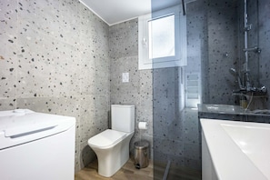 Une salle de bain moderne équipée de toilettes, d’un bidet et d’une douche.