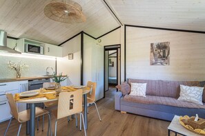Eine moderne Küche mit Mikrowelle, Esstisch mit Stühlen und einer Couch im Wohnbereich.