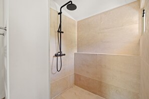 A shower with a handheld showerhead, a wall-mounted faucet, and beige tiled walls. - Les 3 thyms - Avec Piscine Privée - (Méounes-lès-Montrieux)