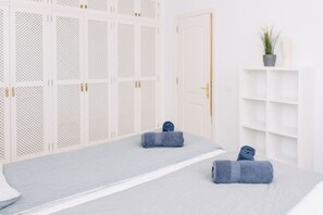 A room with a bed, a white wardrobe, a plant, and a mannequin head. - Bright 1-Bedroom Apartment with Private Terrace and Views | Pool (Playa de las Américas)