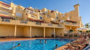 A swimming pool with people in it, surrounded by a building with balconies. - Bright 1-Bedroom Apartment with Private Terrace and Views | Pool (Playa de las Américas)