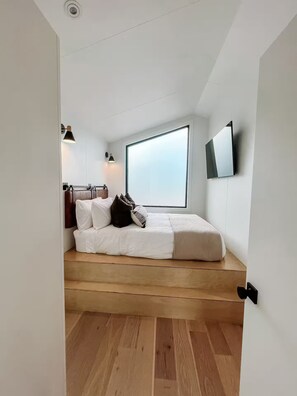 A bedroom with a bed, a window, a TV, and a door. - #2 Peakview @ Royal Gorge (Cañon City)