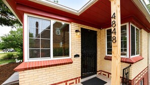 A two-story house with a red and beige exterior, a black front door, and a mailbox. - Stay In The Quiet Side of Denver by Sloan’s Lake (Denver)