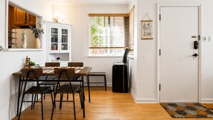 A compact living space with a dining area, a compact kitchen, a window with blinds, a door with a lock, and a small air purifier. - Stay In The Quiet Side of Denver by Sloan’s Lake (Denver)