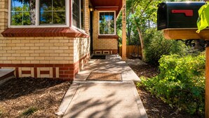 A house with a front porch, a mailbox, and a well-maintained garden. - Stay In The Quiet Side of Denver by Sloan’s Lake (Denver)