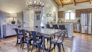 Een ruime keuken met een houten plafond, een groot eiland met zitplaatsen en moderne, roestvrijstalen apparatuur.