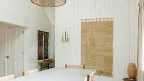 A dining area with a white table, woven chairs, a woven rug, and a woven lamp. - The Still House ~ Acreage · Hot Tub · Sauna · Gym (Bend)