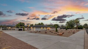 A residential property with a paved driveway, a small house, and a landscaped garden with rocks and trees. - YNotStay_GilbertAZ - Spacious Gilbert Getaway Private Pool Home Retreat (Gilbert)