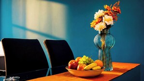 Ein Tisch mit einer Obstschale und einer Blumenvase.